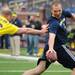 Bob Fraumann touches Mark Bihl during the Victors Classic alumni football game at Michigan Stadium on Saturday. Melanie Maxwell I AnnArbor.com